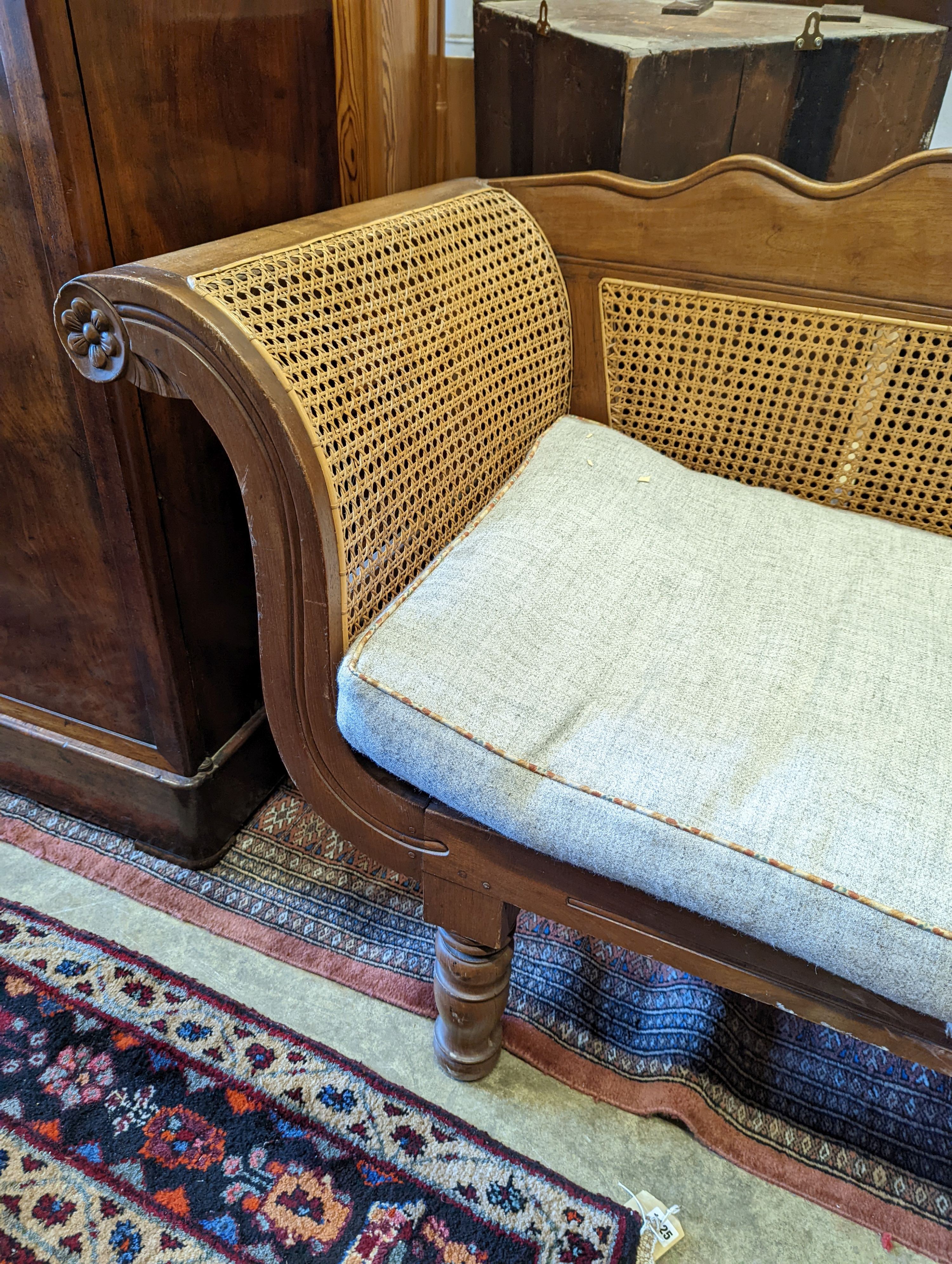 A Colonial caned teak settee with loose cushion seat, length 214cm, depth 62cm, height 95cm